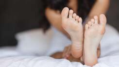 Close-up image of feet of a woman lying in bed