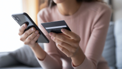 person holding credit card and phone