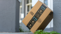 Amazon Prime package box with purchased online products delivered in front of house door.
