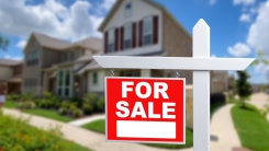For sale sign in front of house