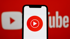 YouTube Music logo on a phone over the YouTube logo in the background