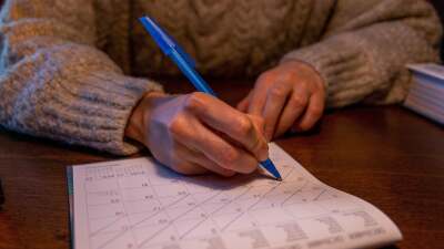 person crossing days off a calendar with a pen