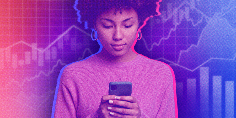 Woman looking at phone against stock market background