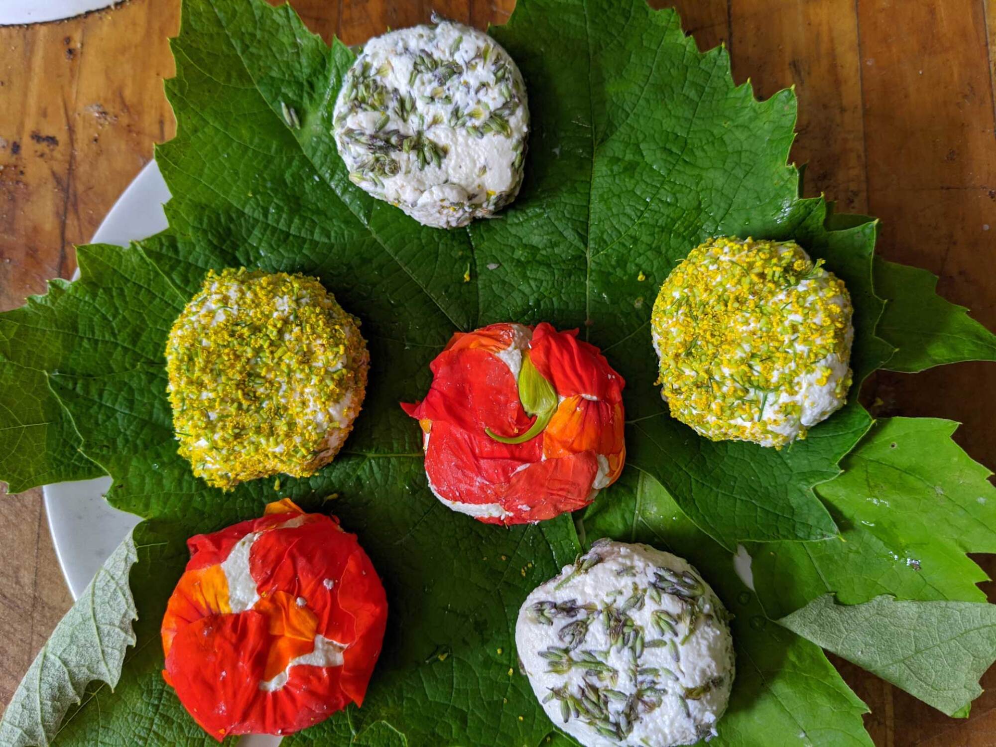 Nasturtiums on outside of small goat cheese wheels