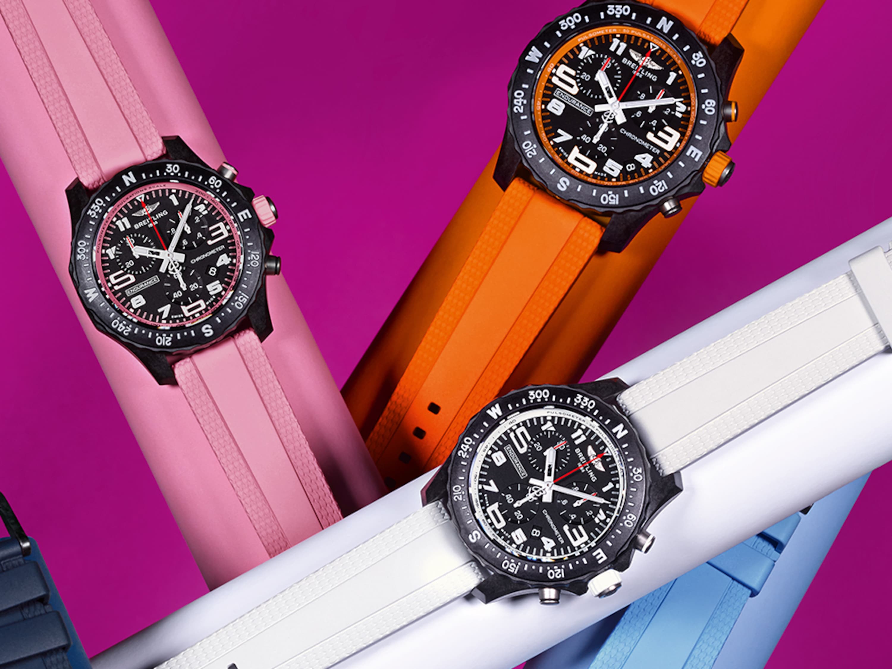 Six Endurance Pro watches in the colors pink, orange, white, light blue, dark blue and purple against a purple background.